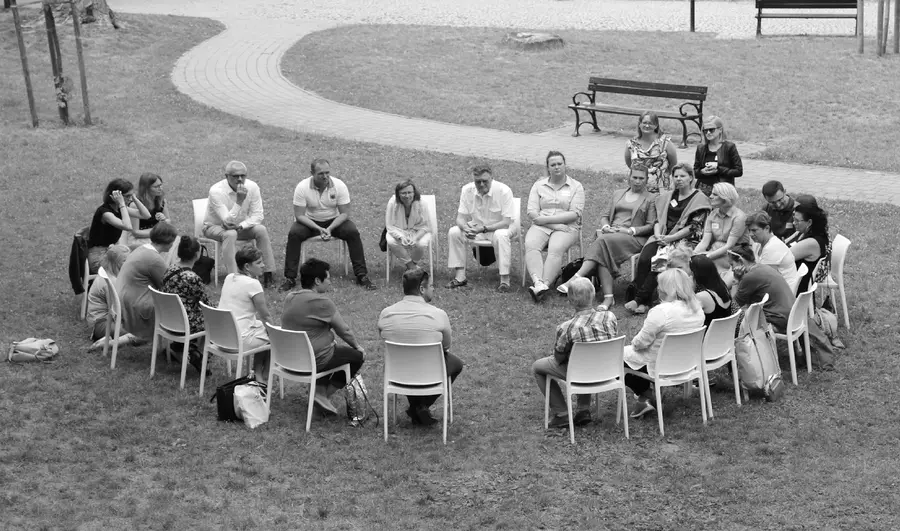 People sitting in a circle on a lawn